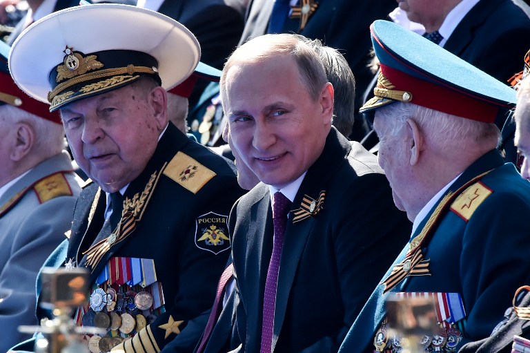 Russian President Vladimir Putin (C) attends the Victory Day military parade at Red Square in Moscow on May 9, 2016. Russia marks the 71st anniversary of the Soviet Union's victory over Nazi Germany in World War II. / AFP PHOTO / KIRILL KUDRYAVTSEV